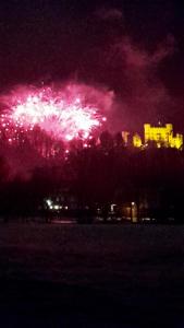a firework display in the sky over a city at night at Romantic-Pension Albrecht - since 1901 in Hohenschwangau