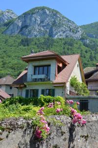 una casa su una roccia con una montagna sullo sfondo di La-Villanelle - Magnifique vue sur le lac, 5 minutes à pied de la plage a Veyrier-du-Lac