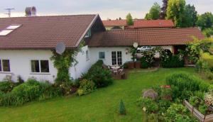 a small white house with a yard with a yard at Studio Murnauer Moos in Murnau am Staffelsee