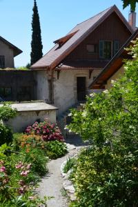 una casa con un giardino con fiori di fronte di La Villanelle - Magnifique vue sur le lac, 5 minutes à pied de la plage a Veyrier-du-Lac