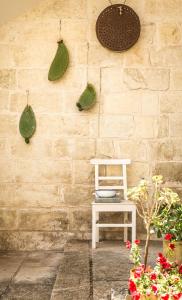 a brick wall with a white chair and plants at La Muzza Bed & Breakfast in Zollino