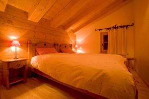 ein Schlafzimmer mit einem Bett und einer Lampe auf einem Tisch in der Unterkunft BnB Les Sapins Bleus in Verbier