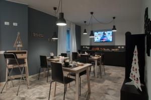 a dining room with tables and chairs and a tv at Relais Merizzi in Tirano