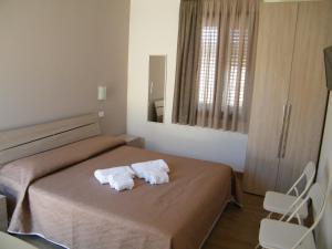 a bedroom with a bed with two towels on it at Il corso Favignana in Favignana