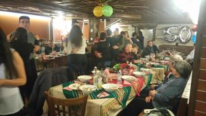 eine Gruppe von Menschen, die an Tischen in einem Restaurant sitzen in der Unterkunft Guest House H Dzhogolanov in Kopriwschtiza