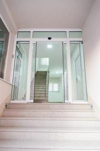 a building with glass doors and stairs in front at Vila Markovic-a in Soko Banja