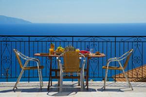 a table and chairs on a balcony with the ocean at Summer Dream in Vlachata