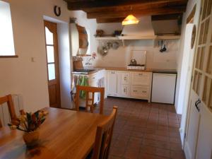 a kitchen with a wooden table and a dining room at Gite, Close To Hautecombe Abbey, Lac du Bourget in Grumeau