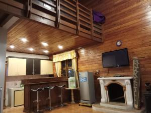 a kitchen with a fireplace and a flat screen tv at Vila Kota Bunga Private Pool in Puncak