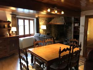 Un comedor con mesa y sillas de madera. en Apartaments Can Bundanci, en Setcases