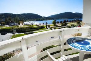 uma varanda com uma mesa e vista para a água em Résidence Plaisance em Gérardmer