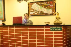 a woman sitting at a counter with a laptop at Hotel Buddha Land in Kathmandu