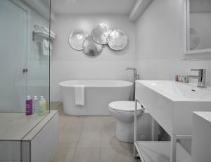 a white bathroom with a toilet and a sink at Coast Canmore Hotel & Conference Centre in Canmore