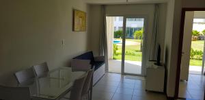 a dining room with a glass table and a television at Apartamento 3 Quartos Tree Bies Resort Subauma in Subaúma