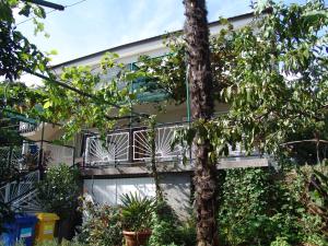 ein Haus mit einem Balkon und einem Baum in der Unterkunft Sobe Bozica in Krk