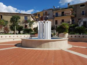 a fountain in the middle of a courtyard with buildings at Casa Centola Palinuro in Centola