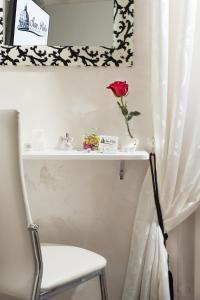 a white shelf with a rose in a vase on it at San Pietro Panoramic View in Rome