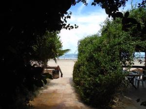 un sentiero che conduce a una spiaggia con tavolo e sedie di Pousada Vira Sol a Trairi