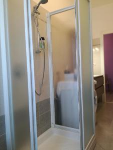 una doccia con porta in vetro in bagno di Casa RA a Torino
