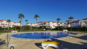 einen Pool in einem Garten mit Palmen und Häusern in der Unterkunft casa luxury 2 nudista in Vera