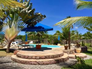 a patio with a pool and a table and umbrella at Bahiadomizil in Canavieiras