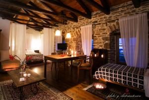 un salon avec une table et un mur en pierre dans l'établissement Archontiko Soulioti, à Ayiá