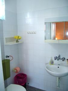 a white bathroom with a sink and a toilet at Sobe Bozica in Krk