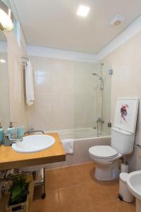 een badkamer met een wastafel, een toilet en een bad bij Belém 147 Apartment in Lissabon