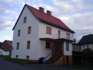 a large white house with a red roof at Haus-Dorfidyll in Spangenberg