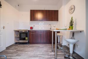 a kitchen with wooden cabinets and a counter top at Small House in Green area in Budapest