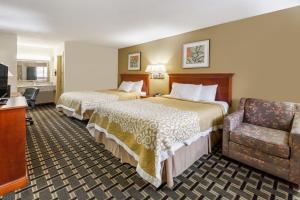 a hotel room with two beds and a chair at Days Inn by Wyndham Kent - Akron in Kent +19 photos