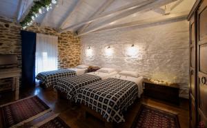 - 2 lits dans une chambre avec un mur en pierre dans l'établissement Archontiko Soulioti, à Ayiá 161 autres photos