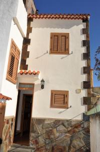 a white building with wooden windows and a door at Casa Teresa Las Vegas in Valsequillo