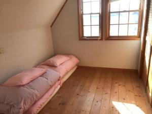 1 Schlafzimmer mit 2 Betten und 2 Fenstern in der Unterkunft Guesthouse Irago in Tahara
