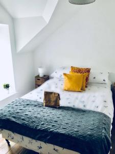 - une chambre avec un lit doté de draps blancs et d'oreillers jaunes dans l'établissement Causeway Coast Townhouse, à Ballycastle