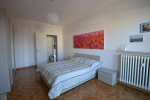 ヴァレーゼにあるBiroldi Apartmentのベッドルーム1室(ベッド1台付)が備わります。壁には絵画が飾られています。