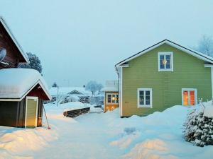 a house with snow in front of it at Apartment Suutarintie - Authentic Lappish experience by the River in Rovaniemi
