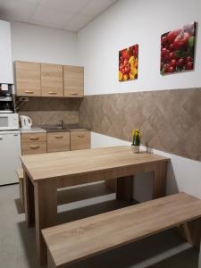 a kitchen with a wooden table in a kitchen at Szilas Park Motel in Nagytarcsa