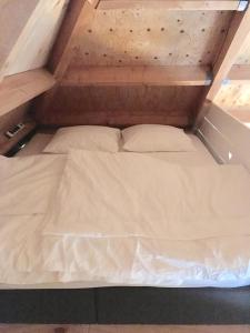 ein Bett mit zwei Kissen darauf in einem Zimmer in der Unterkunft Groeten uit Hoogmade - rural cottage in Hoogmaden + 26 Fotos