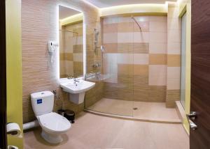 a bathroom with a toilet and a sink and a shower at Monopoly Hotel in Otopeni