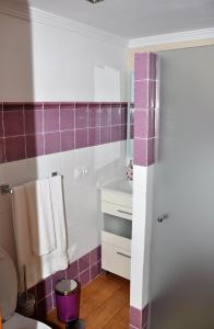 uma casa de banho com paredes em azulejo roxo e branco em Casa Teresa Las Vegas em Valsequillo