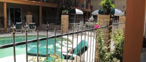 a fence next to a swimming pool with chairs at Stage Stop Inn in Patagonia +36 photos
