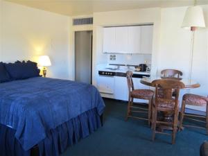 a bedroom with a bed and a table and a kitchen at Stage Stop Inn in Patagonia