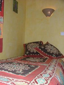 a bedroom with a bed with a blanket on it at Le Calmadou in Formiguères