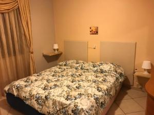 um quarto com uma cama com um edredão floral em Roy Home em Acerra