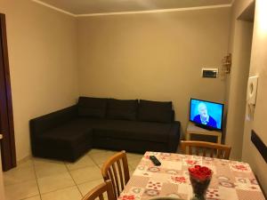 uma sala de estar com um sofá preto e uma mesa em Roy Home em Acerra