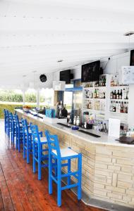 um bar com cadeiras azuis e um balcão em Tasmaria Aparthotel em Pafos
