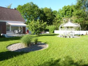 un jardín con cenador y patio en meine-nordsee-fewo, en Esens
