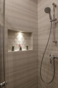 ein Badezimmer mit Dusche und zwei Pflanzen auf einem Regal in der Unterkunft Comfort Stay - Klaipeda in Klaipėda