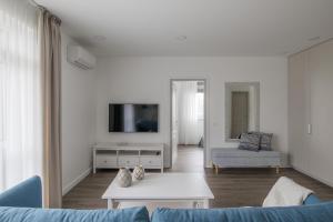 a living room with a blue couch and a tv at Comfort Stay - Klaipeda in Klaipėda